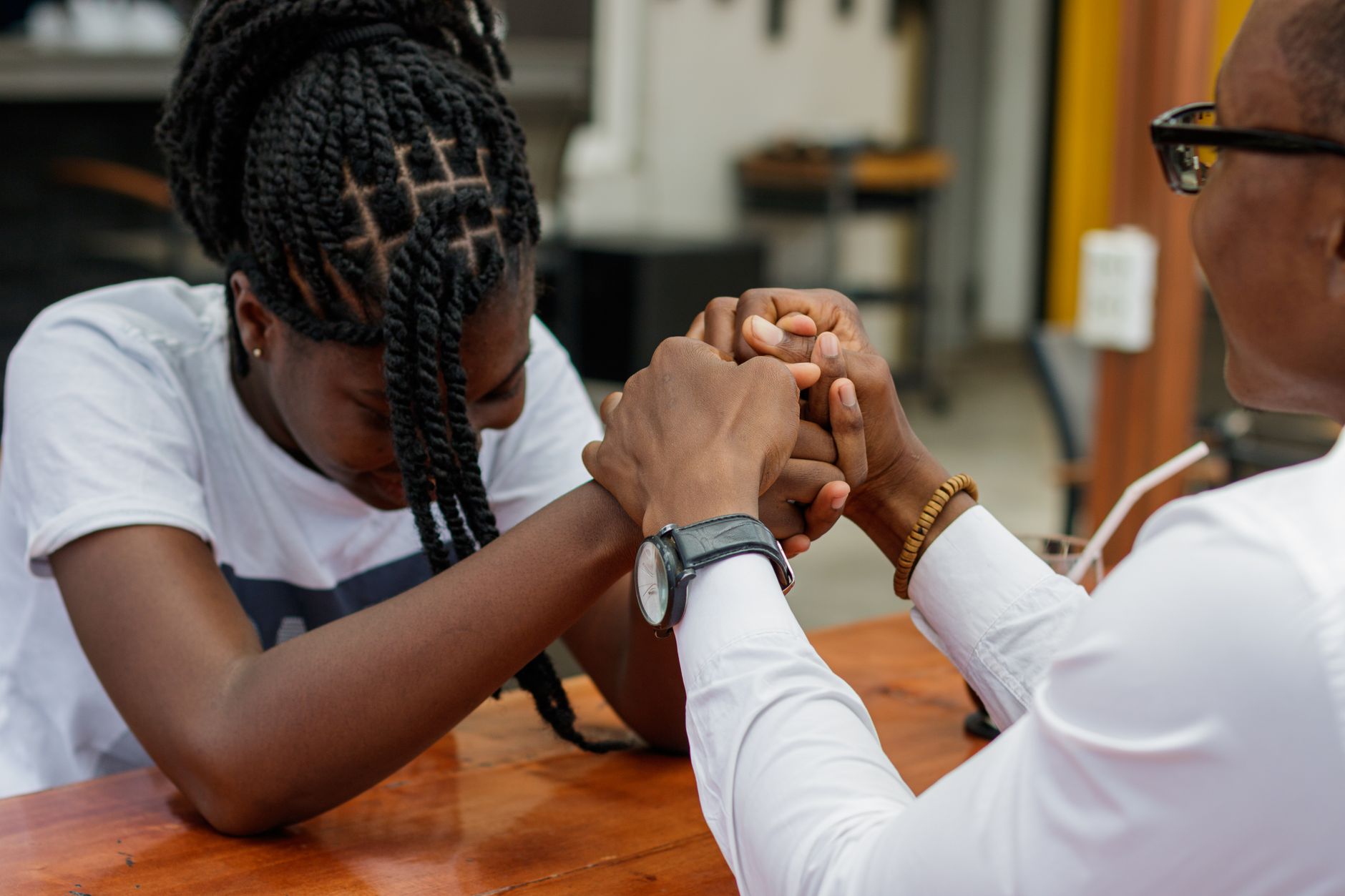 A couple shares a tender moment at a cafe in Accra, symbolizing love and connection.