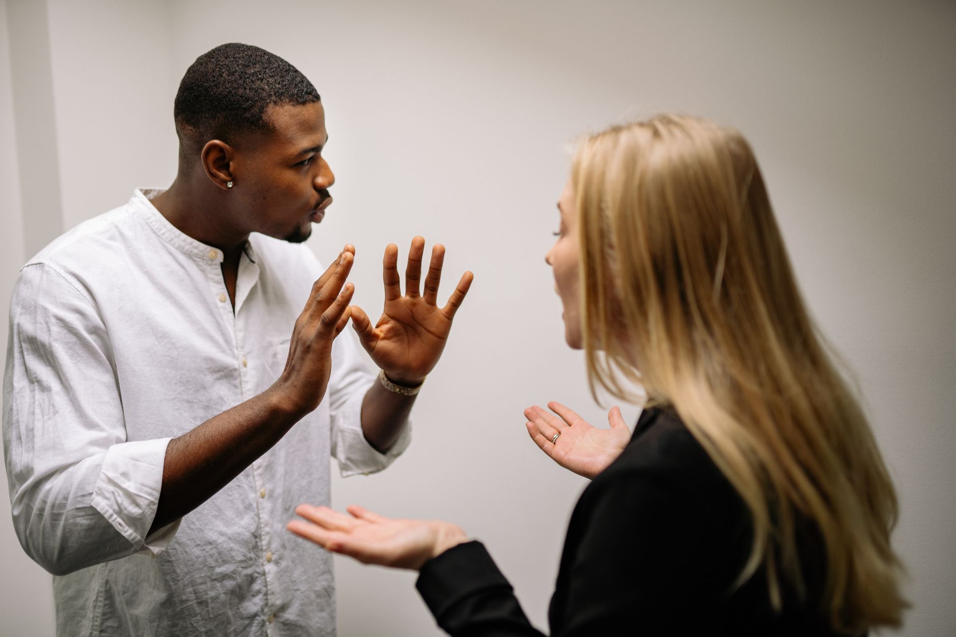 Frustrated coworkers in heated discussion, expressing disagreement in office setting.